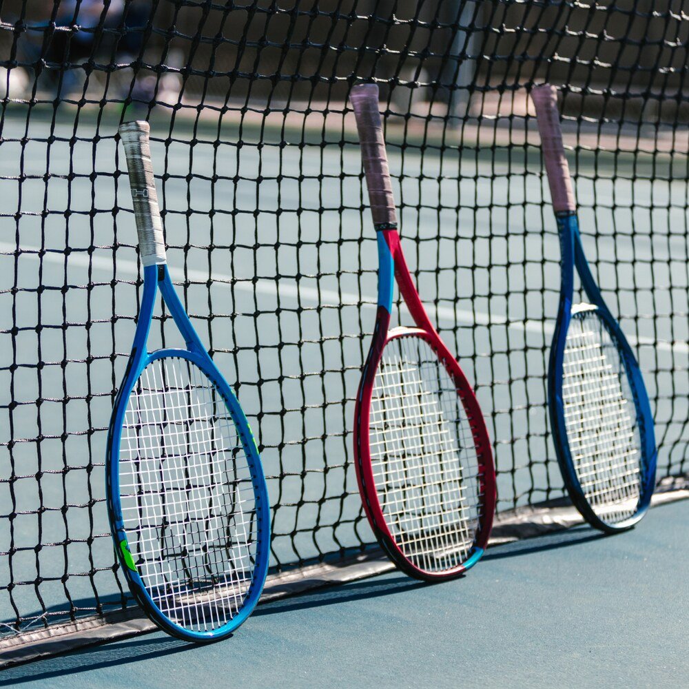 Tennis rackets leaning against the net